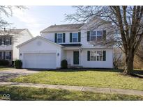 Charming two-story home with a well-maintained lawn, attached two-car garage, and a classic green door at 6513 Kingsbury Way, Zionsville, IN 46077