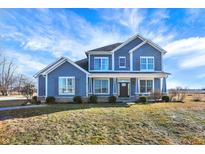 Inviting two-story home featuring blue siding, classic shutters, and a well-manicured lawn at 725 E County Rd 600 N, Pittsboro, IN 46167