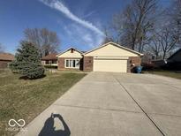 Charming brick home with a well-manicured lawn and a spacious driveway leading to an attached two-car garage at 8023 Dark Star Dr, Indianapolis, IN 46217