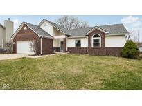 Inviting brick and siding exterior featuring an attached garage and well-maintained lawn at 8328 Pebble Beach Ct, Indianapolis, IN 46234