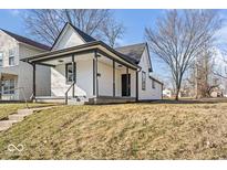 Charming home featuring a covered front porch, complemented by black trim accents and a well-maintained lawn at 866 W 29Th St, Indianapolis, IN 46208