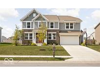 Charming two-story home featuring gray siding, brick accents, landscaped yard, and a basketball hoop above the garage at 1040 Arthur Ct, Greenfield, IN 46140