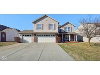 Charming two-story home with a three-car garage and well-maintained front yard on a sunny day at 11624 Eldridge Dr, Indianapolis, IN 46235