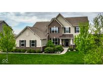 Beautiful two-story home with brick and siding exterior, professional landscaping, and lush green lawn at 12127 Whisper Ridge Dr, Noblesville, IN 46060