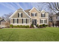 Charming two-story home with a manicured lawn, stone accents, and black shutters on a sunny day at 12433 Harvest Glen Blvd, Fishers, IN 46037