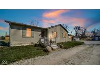 Charming single-story home featuring a rustic exterior and lovely front porch under a beautiful sunset at 1849 E Thompson Rd, Indianapolis, IN 46227