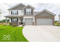 Charming two-story home with brick accents, a manicured lawn, and a spacious three-car driveway at 2290 Oakmont Dr, Plainfield, IN 46168