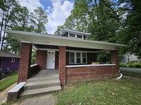 Charming brick bungalow featuring a cozy front porch and classic architectural details at 3560 N Gale St, Indianapolis, IN 46218