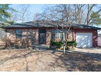 Charming brick home featuring a well-maintained yard and attached one car garage at 3813 N Hartman Dr, Indianapolis, IN 46226