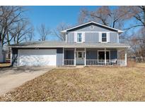 Charming two-story home featuring a welcoming front porch and attached two-car garage at 3918 Oil Creek Dr, Indianapolis, IN 46268