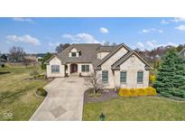 Stunning brick home with a well-manicured lawn and long driveway at 5842 W Boulder Creek Dr, New Palestine, IN 46163