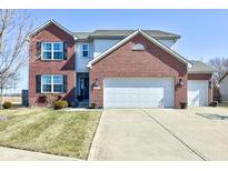 Charming two-story brick and siding home with attached two car garage and manicured lawn at 983 Geronimo Dr, Greenfield, IN 46140