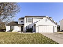 Charming two-story home with a two-car garage and well-maintained lawn under a blue sky at 12683 Raiders Blvd, Fishers, IN 46037