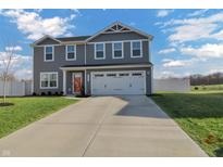 Charming two-story home features a two-car garage, well-manicured lawn, and lovely gray siding at 13777 N Rising Sun E Cir, Camby, IN 46113