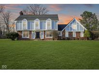 Charming two-story home with brick and light blue accents and a large, well-maintained lawn at 13813 Painter Ct, Carmel, IN 46032