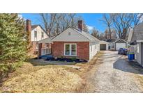 Charming brick home featuring a well-maintained lawn and a cozy front porch at 1521 Kessler Blvd E Dr, Indianapolis, IN 46220