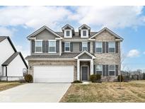 Charming two-story home with brick and vinyl siding, a well-manicured lawn, and an attached two-car garage at 16406 Taconite Dr, Noblesville, IN 46060
