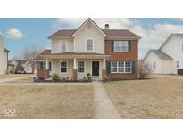 Charming two-story home featuring a welcoming front porch and a combination of brick and siding accents at 17953 Forreston Oak Dr, Noblesville, IN 46062