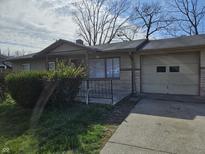 Cozy single-story home featuring a charming front porch and attached one-car garage at 3044 Manor Ct, Indianapolis, IN 46218