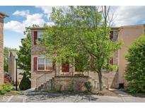 Charming brick townhome featuring red shutters, a brick staircase, and a well-maintained front yard at 3052 Skylar Ln, Indianapolis, IN 46208