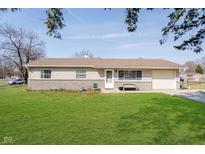Charming single-story home with a well-manicured lawn, a bench, and an attached garage, perfect for easy living at 348 W Stop 11 Rd, Indianapolis, IN 46217