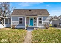 Charming single-Gathering home featuring a vibrant blue front door and a well-manicured lawn at 4529 Norwaldo Ave, Indianapolis, IN 46205