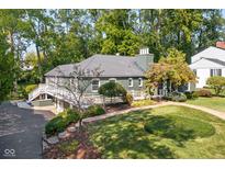 Charming home with a white fence, landscaped yard, and lush greenery, creating a serene and inviting curb appeal at 6980 N Pennsylvania St, Indianapolis, IN 46220