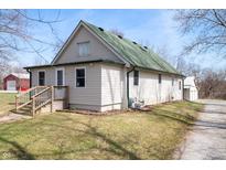 Charming home featuring green roof, siding, and inviting wooden deck in a serene outdoor setting at 712 N Pendleton Ave, Pendleton, IN 46064