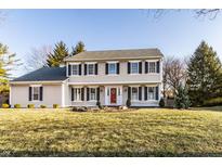 Charming two-story home featuring symmetrical design, black shutters, well-manicured lawn, and a welcoming red front door at 804 Bennett Ct, Carmel, IN 46032