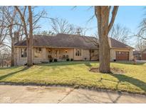 Charming single-story home with stone accents, mature trees, well-maintained lawn, and a welcoming front porch at 8331 Lookout Ct, Indianapolis, IN 46217