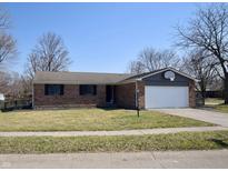 Charming brick ranch-style home with an attached two-car garage, manicured lawn, and mature trees at 8417 Castle Ridge Ln, Indianapolis, IN 46256
