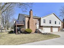 Charming home exterior featuring a brick chimney, an upper deck, and a two-car garage, perfect for suburban living at 9235 Doubloon Rd, Indianapolis, IN 46268