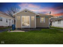 Charming single story home with a well-maintained lawn and neutral-toned siding under a vibrant sunset at 1054 S Whitcomb Ave, Indianapolis, IN 46241