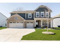 Charming two-story home boasts a three-car garage, manicured lawn, and inviting front porch at 11180 Jubilation Way, Noblesville, IN 46060