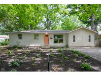 Charming ranch home with light-colored siding, a modern peach door, and a beautifully landscaped front yard at 1740 Haynes Ave, Indianapolis, IN 46240