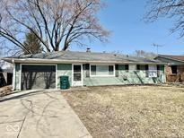 Charming ranch-style home featuring a cozy facade, attached garage, and well-maintained lawn at 2308 W Surrey Dr, Muncie, IN 47304