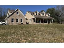 Expansive two-story home featuring a brick facade, inviting front porch, and well-manicured lawn at 3040 Old Morgantown Rd, Martinsville, IN 46151