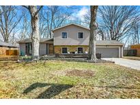 Inviting two-story home featuring neutral siding, stone accents, an attached garage, and a well-maintained front yard at 8211 Taunton Rd, Indianapolis, IN 46260