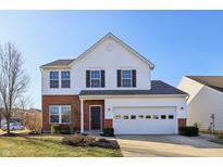 Charming two-story home featuring a brick facade and a well-maintained lawn on a sunny day at 8327 Gates Corner Dr, Indianapolis, IN 46113