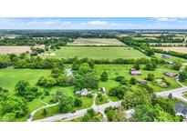 Lush aerial showcases a sprawling property with verdant fields and picturesque buildings at 905 S Maple St, Fortville, IN 46040