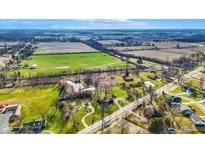 Expansive aerial view of the property showing the surrounding farmland, ponds, and neighborhood at 905 S Maple St, Fortville, IN 46040