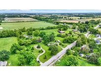 Expansive aerial view of a lush, green property with mature trees and winding paths at 905 S Maple St, Fortville, IN 46040