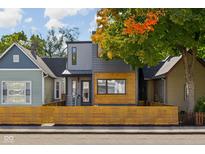 Modern two-story home showcasing unique wood accents and fence and attractive landscaping at 1205 Fletcher Ave, Indianapolis, IN 46203