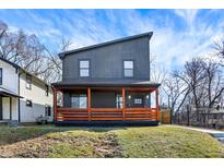 Modern two-story home featuring a front porch with vibrant orange-stained wood and unique architectural design at 1209 N Rural St, Indianapolis, IN 46201