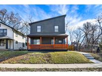 Modern two-story home featuring a front porch with vibrant orange-stained wood and unique architectural design at 1209 N Rural St, Indianapolis, IN 46201