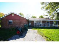 Cozy brick home with a covered porch and a narrow walkway in a charming neighborhood at 1509 E Centennial Ave, Muncie, IN 47303