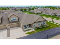 Charming brick townhome with an attached garage and a cozy front porch sitting area at 2326 Saddle Dr, Shelbyville, IN 46176