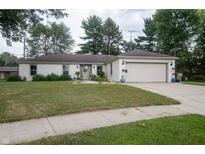 Charming single-story home with a well-manicured lawn, attached garage, and inviting curb appeal at 3335 Woodcrest Ct, Columbus, IN 47203