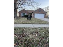 Charming brick home featuring an attached garage and inviting front yard with 'For Sale' sign at 485 Paddlebrook Dr, Danville, IN 46122
