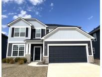 Beautiful two-story home with blue siding, black shutters, and attached two-car garage under a clear blue sky at 6724 Seattle Slew Dr, Whitestown, IN 46075